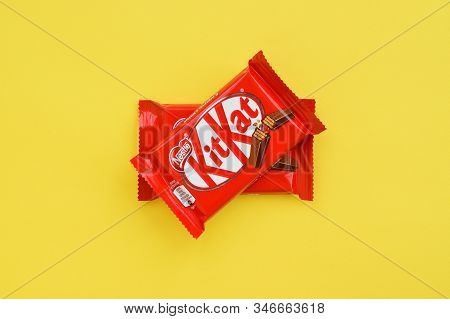 Kit Kat Chocolate Bar In Red Wrapping Lies On Yellow Background. Kit Kat Created By Rowntrees Of Yor