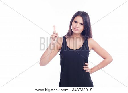 Serious And Interrogative Young Beautiful Girl Pointing Up