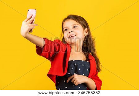 Selfie Time. Small Girl Take Selfie With Smartphone Yellow Background. Little Child Selfie Camera In