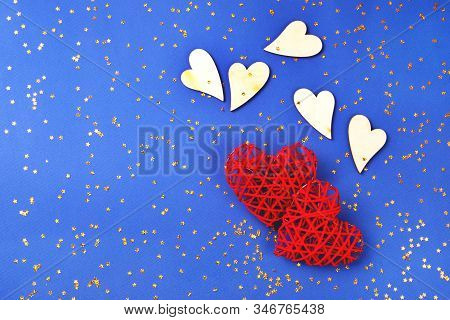 Beautiful Red And Wooden Hearts On Cornflowerblue Background In The Golden Star Sequins. St Valentin
