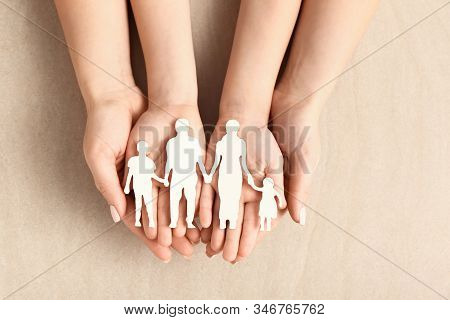 Hands Of Woman And Child With Figure Of Family On Light Background. Adoption Concept