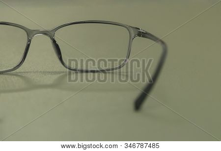 Clear Plastic Glasses, Eyes Closed, Shot Close-up, On A Blurred Green Background. Concept: Beautiful