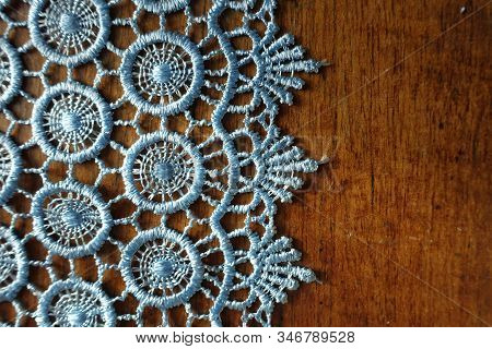 Vertical Edge Of Light Blue Crochet Lace On Wooden Table