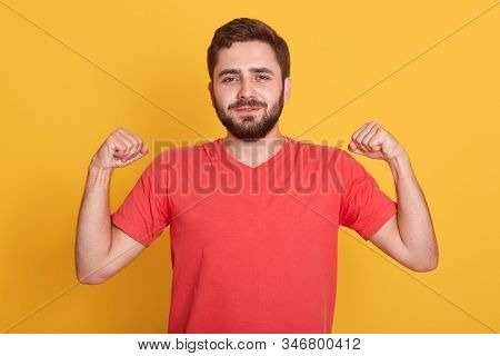 Horizontalshot Of Caucasian Bearded Man Raises Arms To Show His Muscles, Attractive Guy Feels Confid