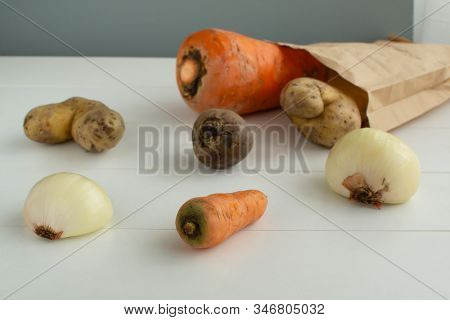 Ugly Vegetables. Vegetables In A Paper Bag On A White Background. The Form Does Not Affect The Taste