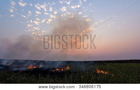 Picture Of A Rice Field In A Rural Area Where Villagers Are Burning Stumps Of Rice. With The Backdro