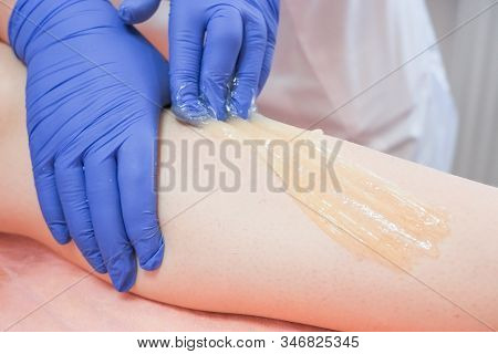 Woman Making Sugaring Hair Removal Procedure At Beauty Salon. Beautician Cosmetologist Make Epilatio