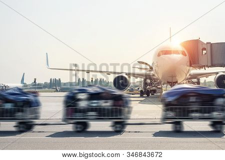 Luggage Motion Blurred Trolley Cart Going Fast Delivering Passenger Baggage To Modern Plane On Taxiw