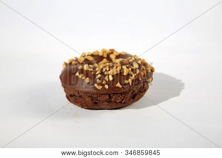 chocolate Donut with peanuts. isolated on white. room for text. clipping path. People world wide enjoy donuts. Enjoy a Donut today. 
