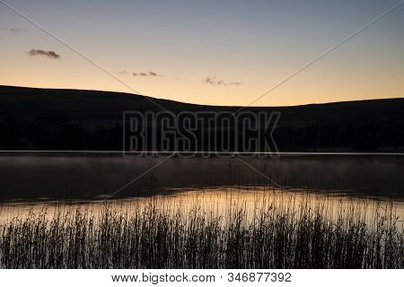 Stunning Sunrise Autumn Fall Landscape Image Of Ullswater In Lake District With Golden Sunlight