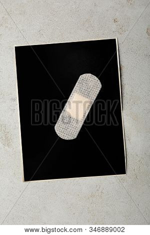 Black Paper Sheet With Sticking Plaster On Light Grey Stone Table, Top View