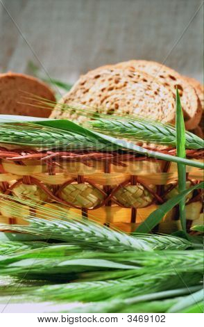 Spicas van rogge naast mand met brood