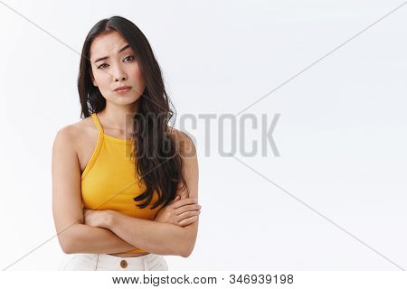 Skeptical, Unimpressed Pretty East-asian Female In Yellow Top, Cross Hands On Chest Defensive And Un