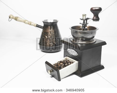 Coffee Beans In A Small Box Of Wooden Coffee Grinder And A Cezva On The Background On White Backgrou