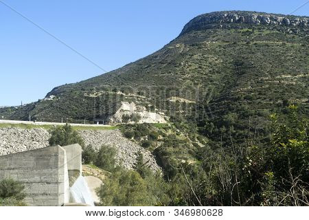 Green Hill In Front Of The Blue Sky And Germasogeia Dam, Cyprus Overflowing After The Heavy Winter R