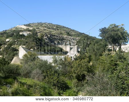 Green Hill In Front Of The Blue Sky And Germasogeia Dam, Cyprus Overflowing After The Heavy Winter R