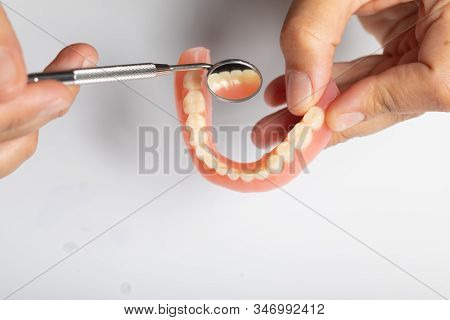 Denture Prosthesis In Doctor Dentist Hands, Checking With Mirror