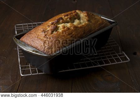 Freshly Baked Banana Bread In Baking Pan On Cooling Rack
