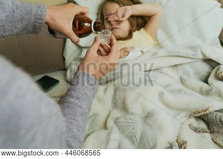 Female Hands Pour Medicine For Sick Little Girl