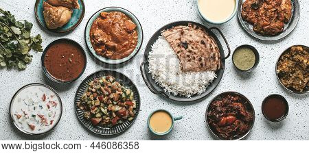 Indian Ethnic Food Buffet On White Concrete Table From Above: Curry, Samosa, Rice Biryani, Dal, Pane