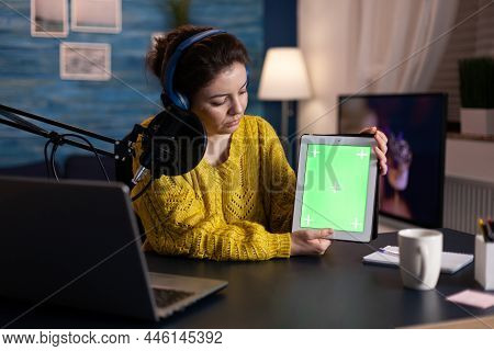 Social Media Creator With Production Headphones Holding Mock Up Green Screen Chroma Key Tablet With 