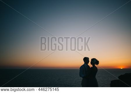 Beautiful Sunset At Sea, A Man And A Woman Hold Hands, Look At Each Other, A Love