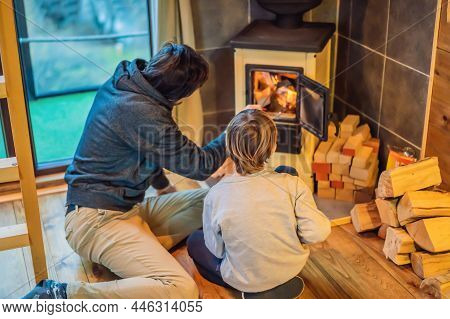 Dad And Son Spend Time By The Fireplace In Glamping. Rest In The Mountains In Glamping. Cozy Firepla