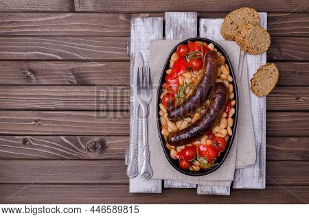 Braised Beans With Vegetables And Fried Sausages On A Wooden Background. Top View.