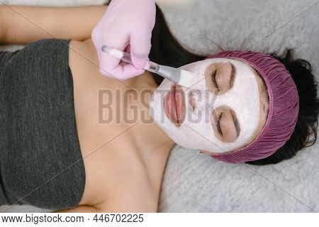 Cosmetologist Applaying Peeling Mask On Female Face In Beauty Salon