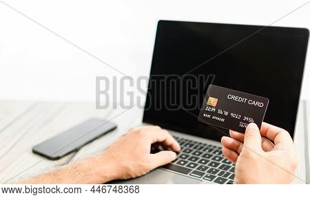 Businessman Holding Credit Card And Pressing Laptop Keyboard. The Concept For Business, Online, Tech