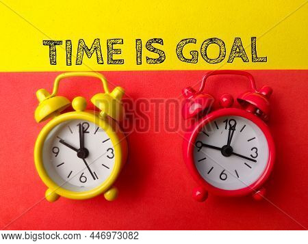 Top View Alarm Clock With Text Tike Is Goal On Red And Yellow Background.