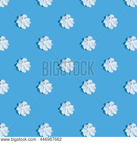 White Meringue With A Shadow On A Blue Background. Delicious Dessert. Seamless Background.