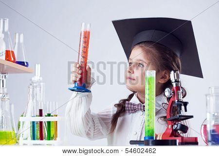 Smart little experimenter looking at test tube