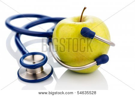 an apple and a stethoscope on a doctor. symbolic photo for healthy and vitamin-rich diet.