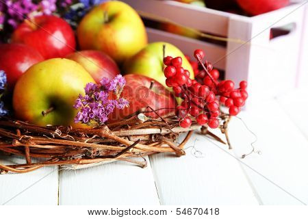 Juicy apples in box on white wooden table