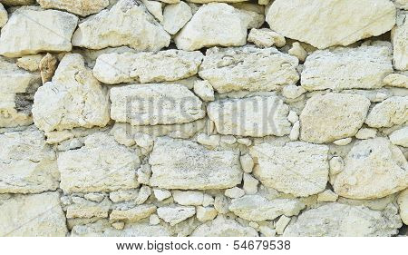 Old weathered stone wall for background. Close-up.