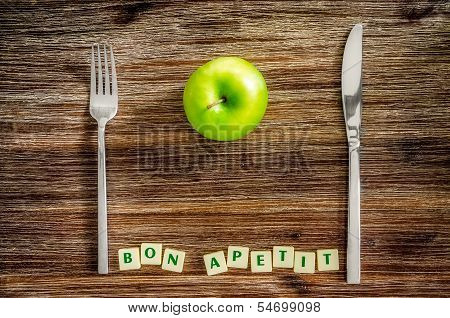 Silverware And Apple On Wooden Table With Bon Apetit Sign