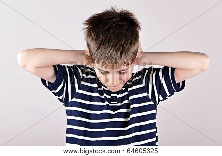 Young boy covering his ears with hands