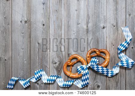 Bavarian pretzels with ribbon on wooden board as a background for Oktoberfest