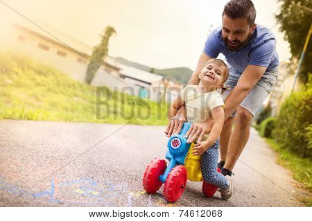 Father and daughter on motorbike in park