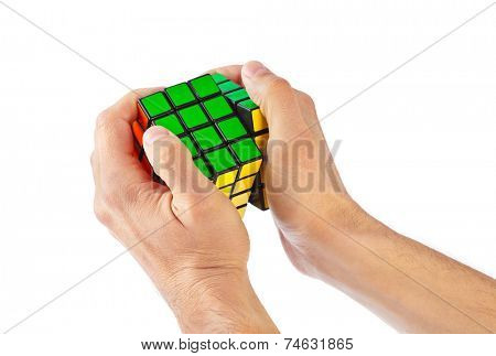 MOSCOW, RUSSIA - August 31, 2014: Hands and Rubik's cube puzzle isolated on the white background. Cube was invented by a Hungarian architect Erno Rubik in 1974.