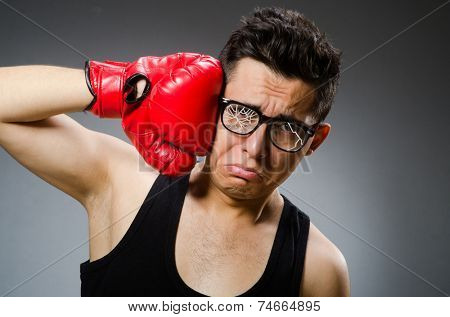Funny boxer with red gloves against dark background