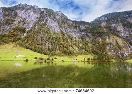  Clouds and mountains reflected in the water. Cloudy day in the Bavarian lake Koenigssee
