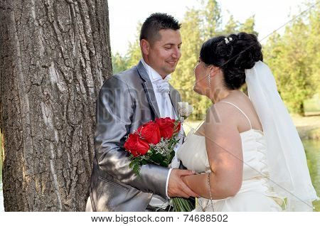 Young bride and groom couple posing outside