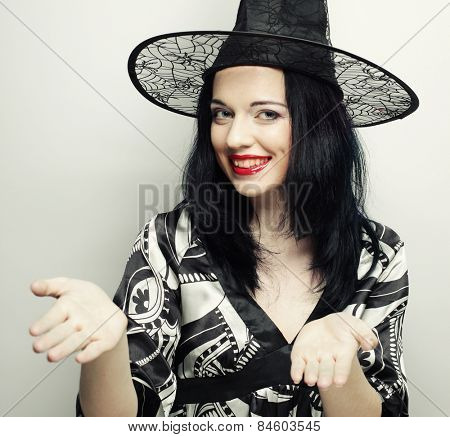 Funny Witch. Young happy woman with canival hat. Studio shot.