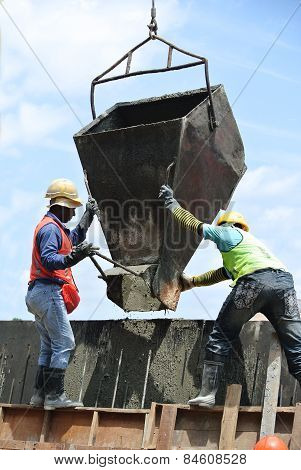 Group of construction workers casting concrete retaining wall