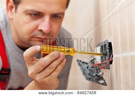 Electrician Checking Wall Fixture With Voltage Tester