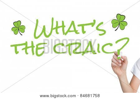 Female hand holding whiteboard marker against shamrock