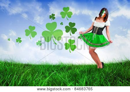 Irish girl smiling against field of grass under blue sky