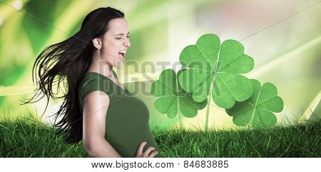 Brunette in green tshirt against dew on the grass close up